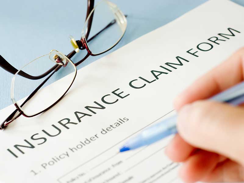 Close up of someone filling out an insurance claim form