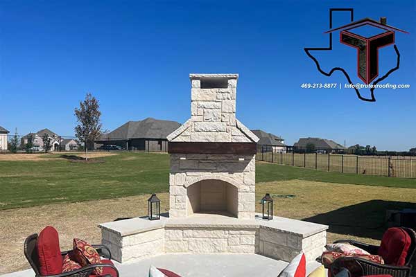 Large open outdoor area with several seats in front of a large white concrete fire place installed by Trutex