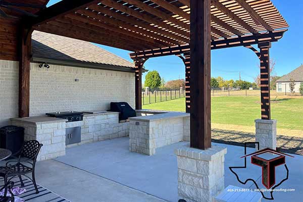 Brown wooden pergola installed by Trutex over a small outdoor kitchen area